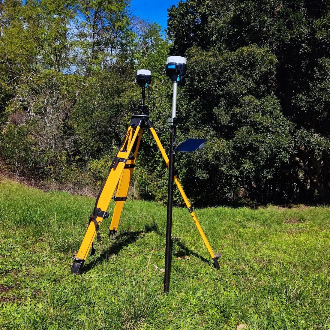 Base y receptor móvil de GPS geodésico midiendo en terreno, al borde del bosque